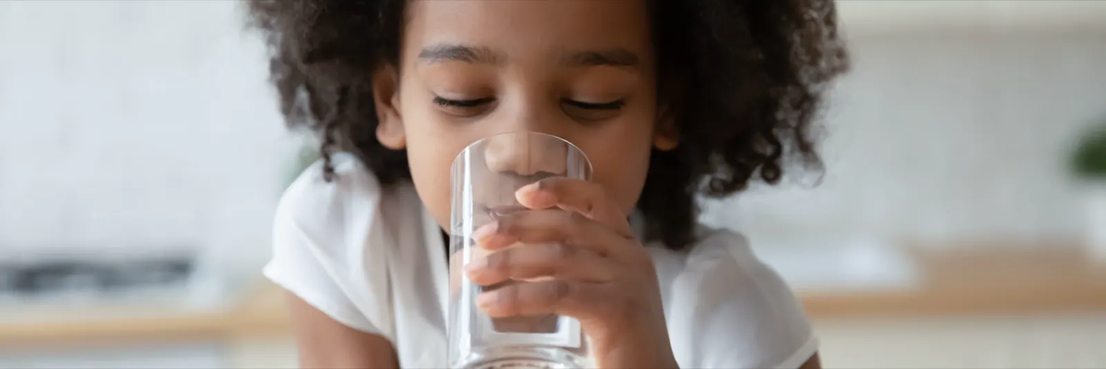 Child drinking water outdoors