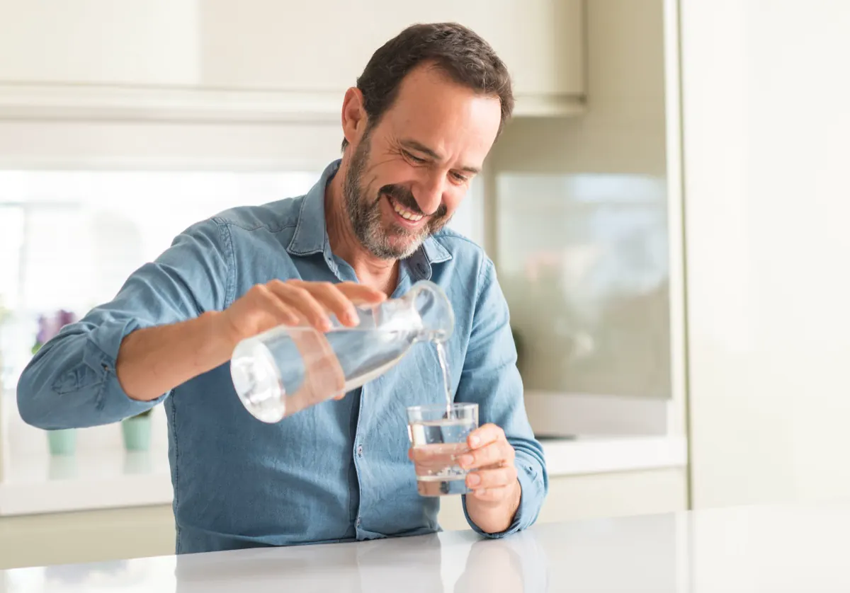 Man pouring a glass of filtered water